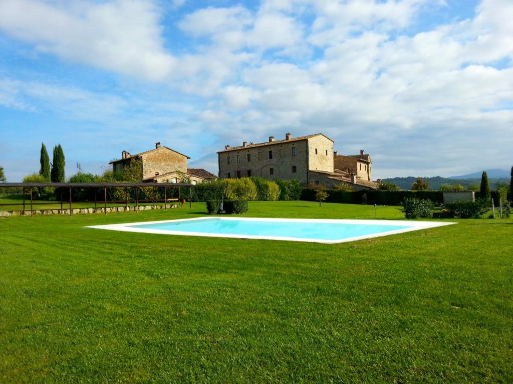 a large grassy field with a large building in the background at Residenza Antica Canonica in Casole dʼElsa
