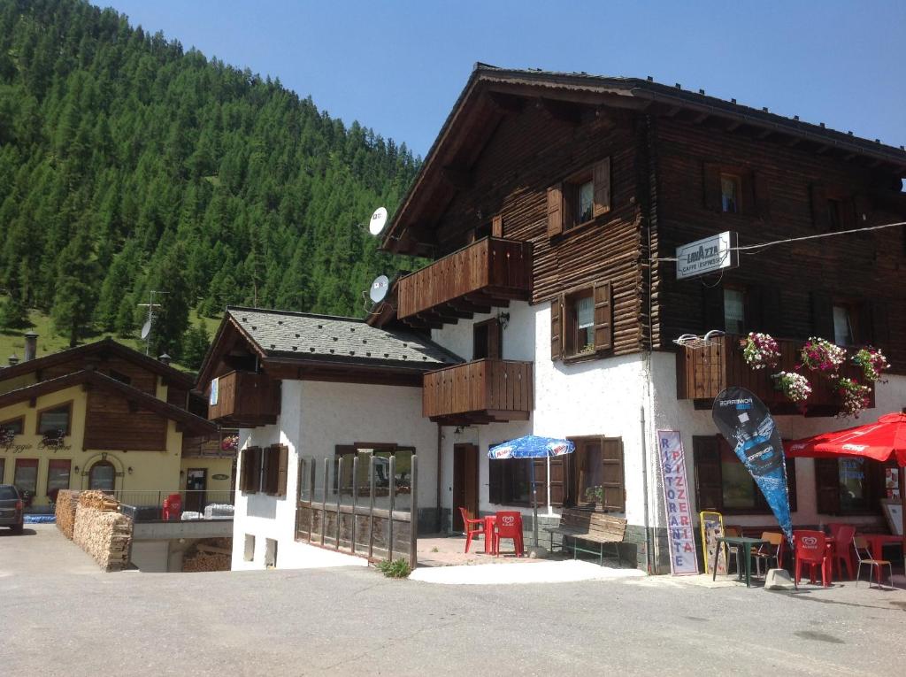a building with tables and chairs in front of it at Baita Veglia in Livigno