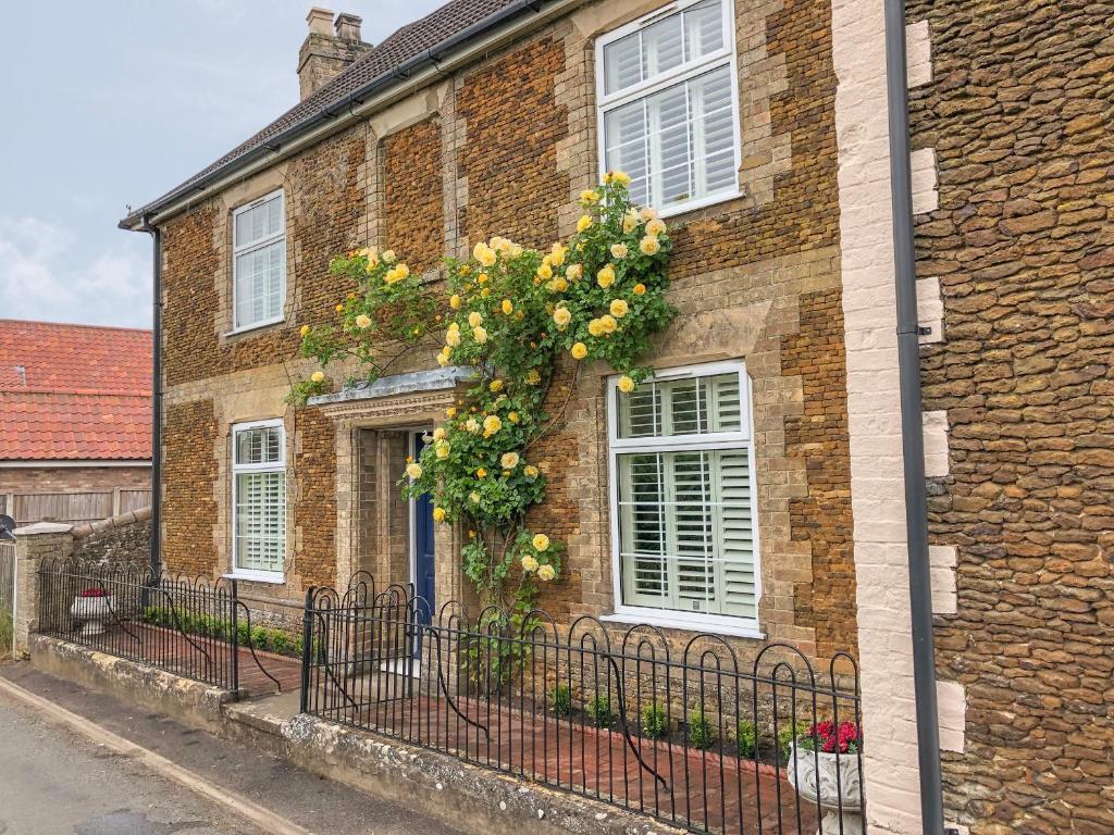 a brick house with a wreath of flowers on it at Bertelle in Grimston