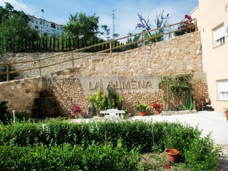 a stone wall with a sign that reads la little me at La Almena in La Iruela