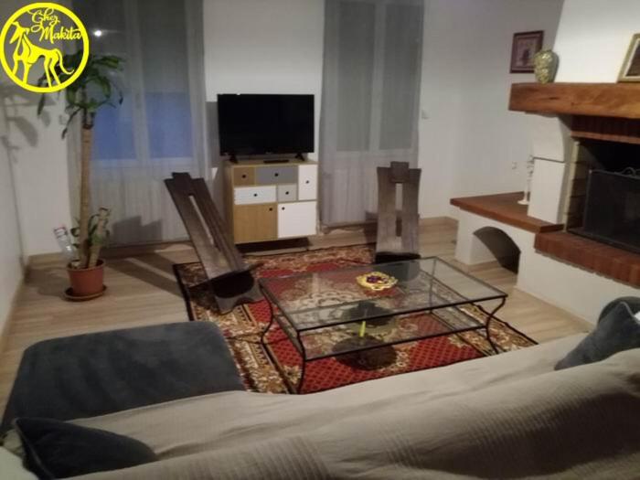 uma sala de estar com um sofá e uma lareira em Chez Makita - RdC em Mirepeisset