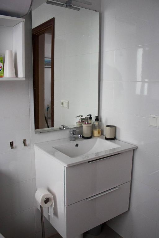 biała łazienka z umywalką i lustrem w obiekcie centrico apartamento nuevo, zona corte ingles w Maladze