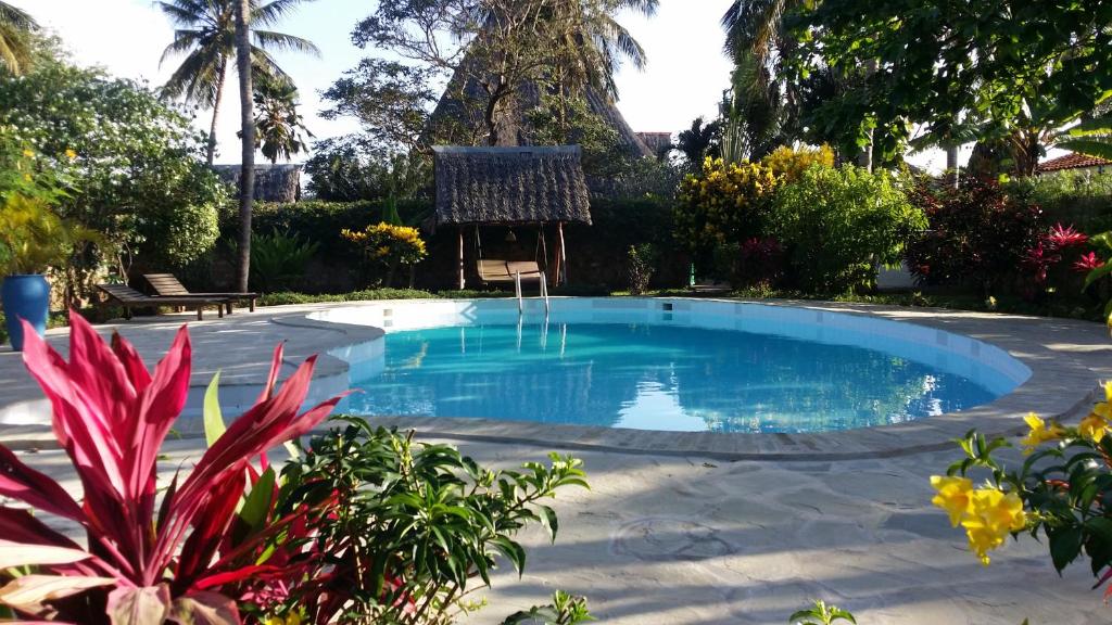 a swimming pool in the middle of a yard at Luxury Villa SOLEIL, Galu Diani Beach in Diani Beach