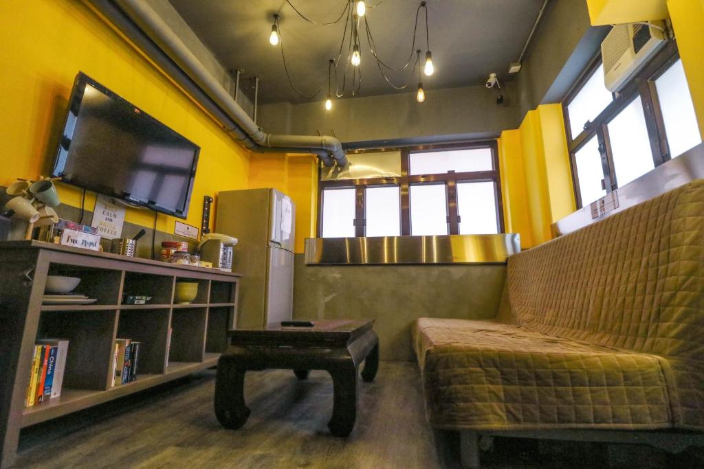 un soggiorno con divano, TV e tavolo di Urban Pack a Hong Kong