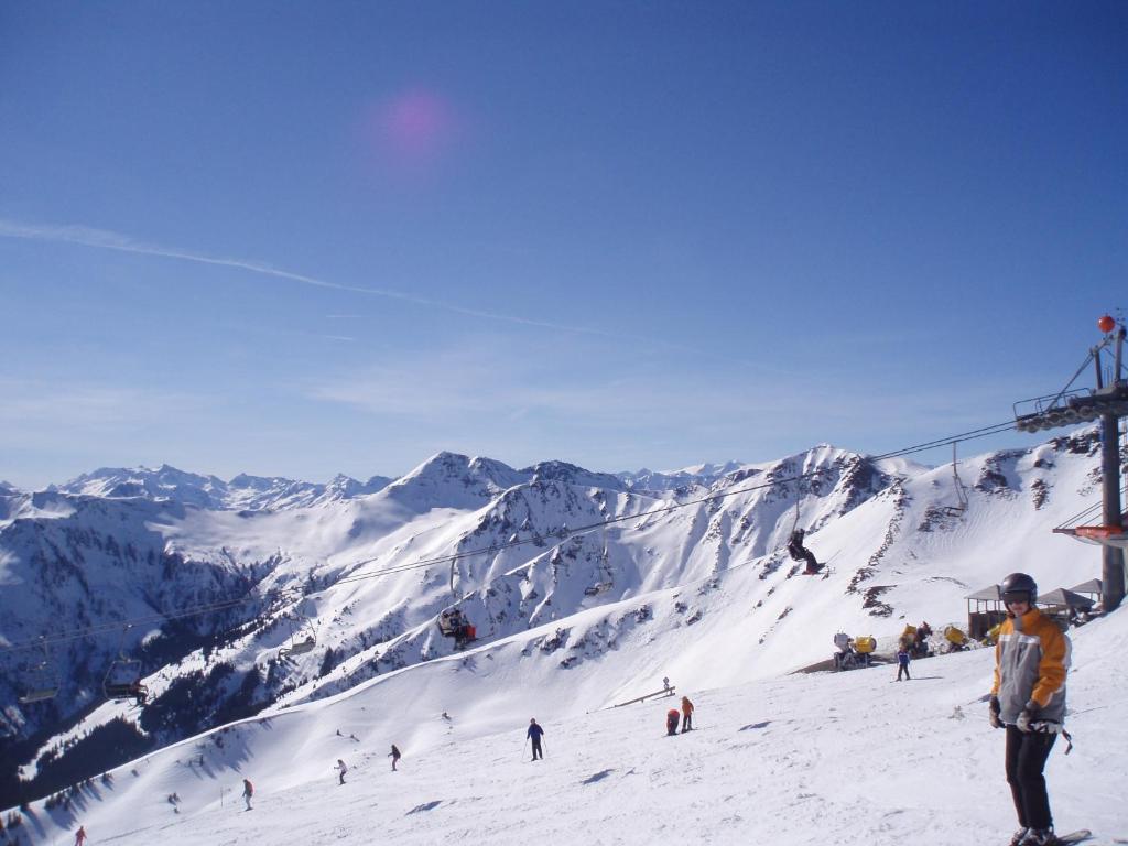 un grupo de personas esquiando por una montaña cubierta de nieve en Ferienwohnung Schwarzbach, en Leogang