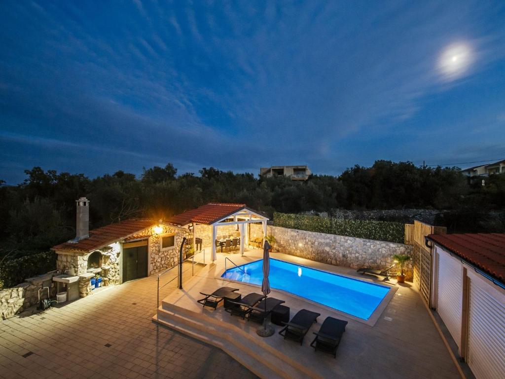 eine Villa mit einem Pool in der Nacht in der Unterkunft Beautiful holiday Home in Mali I with Pool in Mali Iž