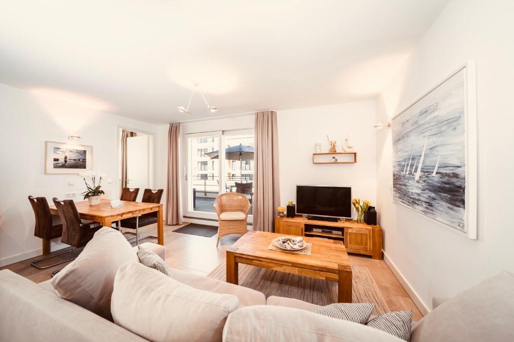 a living room with a couch and a table at Ferienwohnung Ostseeblick WE 15 Villa Seeadler in Börgerende-Rethwisch