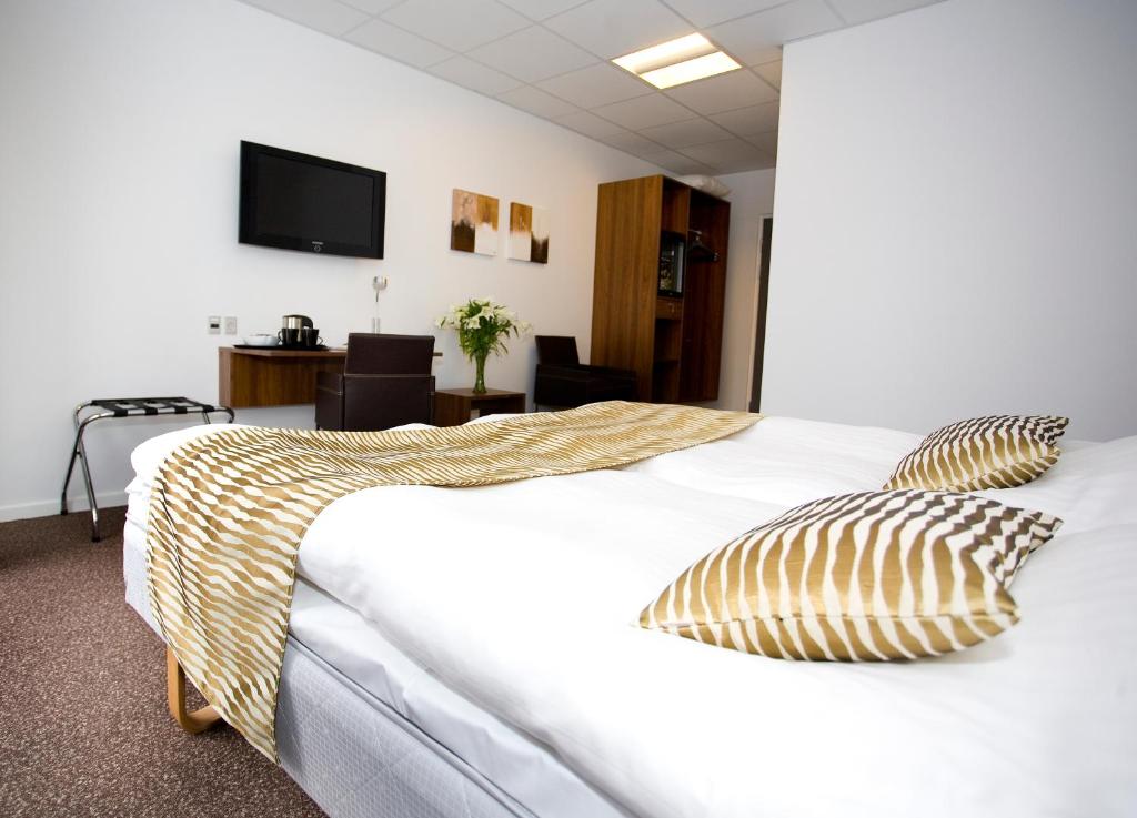 En eller flere senge i et værelse på Hotel Thinggaard