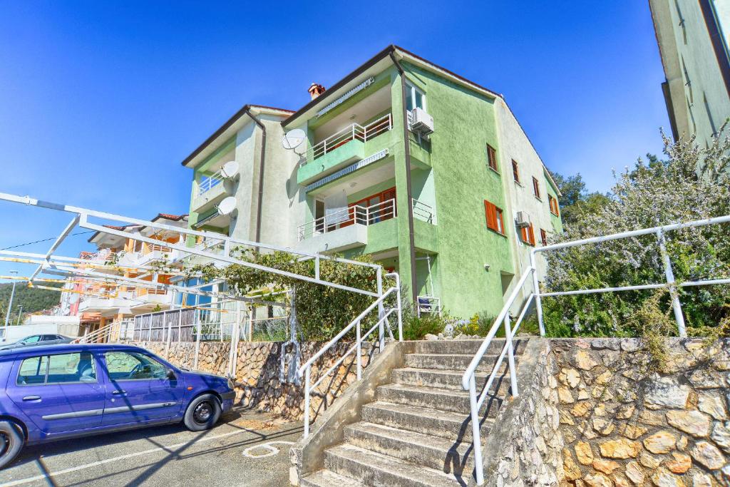 Niebieski samochód zaparkowany przed budynkiem w obiekcie Apartment Zeljko 832 w Rabacu