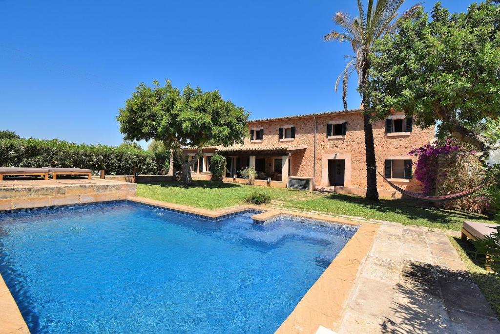 a large swimming pool in front of a house at Finca Siscelis 063 by Mallorca Charme in Santa Maria del Camí