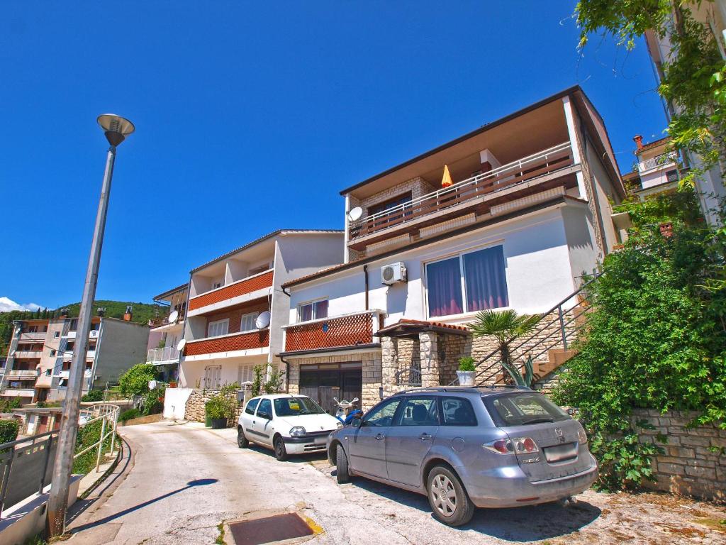 dwa samochody zaparkowane przed budynkiem w obiekcie Apartments and room Rabac 155 w Rabacu