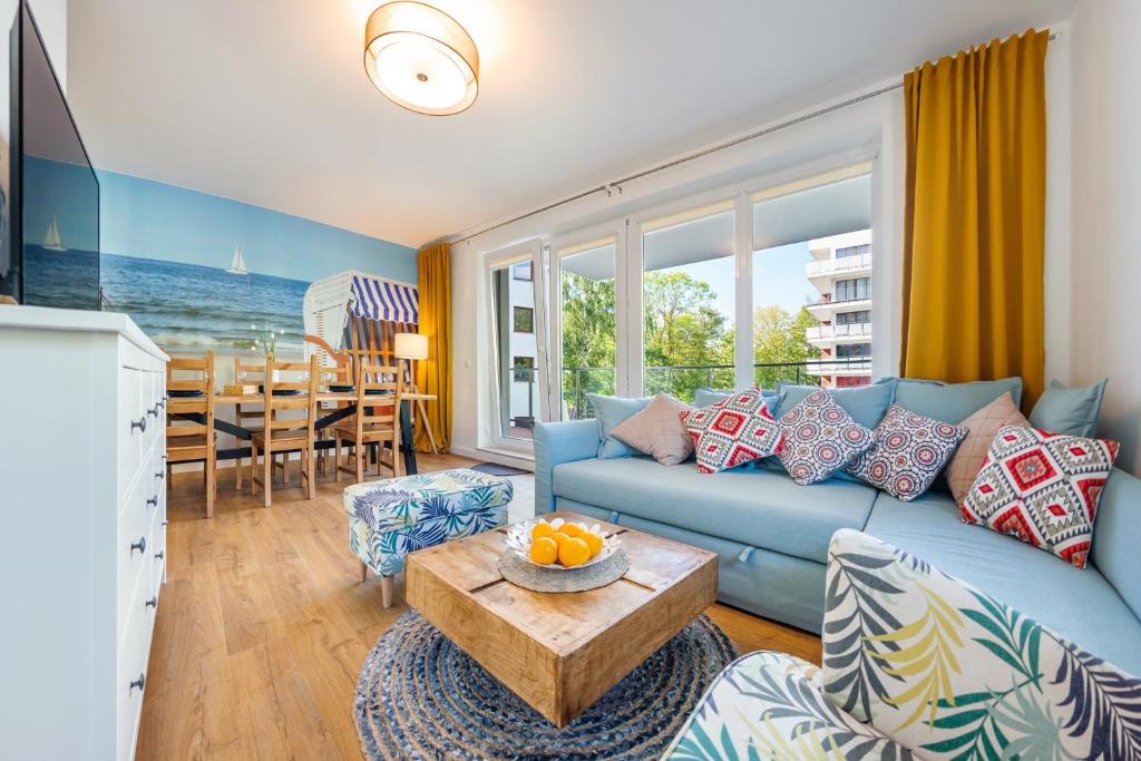 コウォブジェクにあるApartamenty Sun & Snow Wyspa Solnaのリビングルーム(青いソファ、テーブル付)