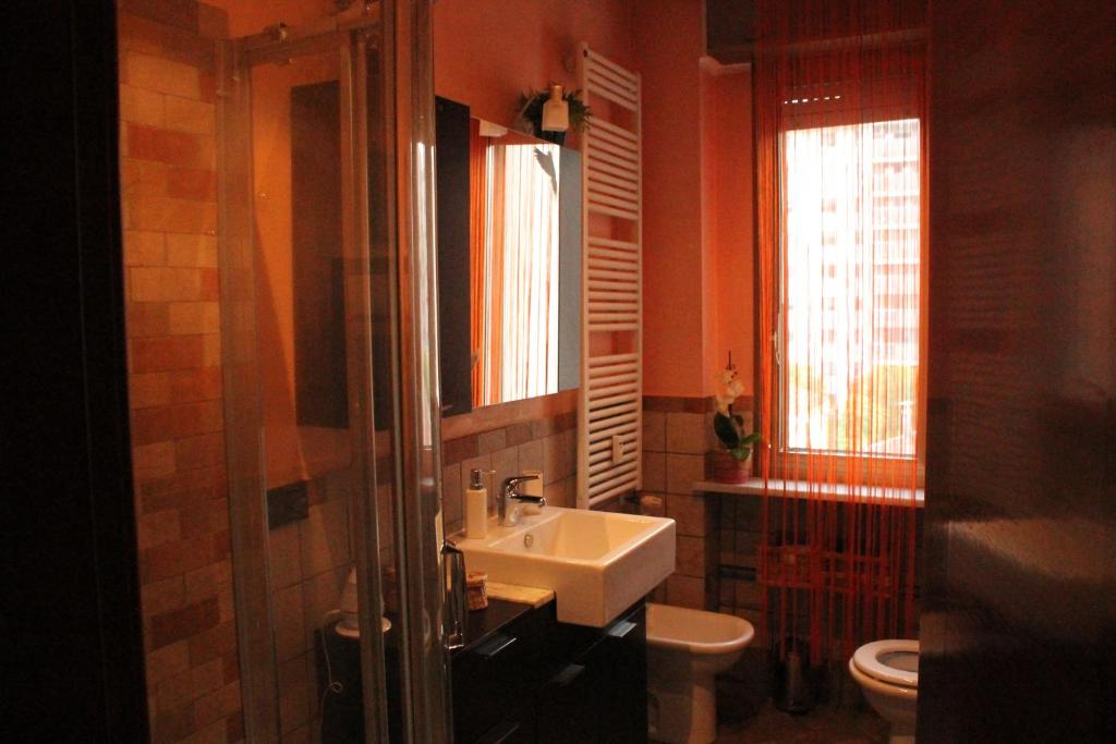 a bathroom with a sink and a toilet and windows at Sweet Home Milano B&B in San Donato Milanese