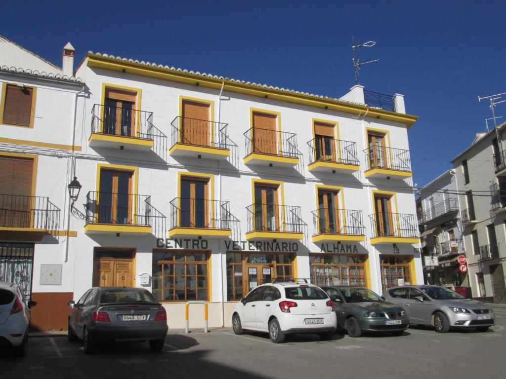 a white building with cars parked in front of it at Apartamento Terranova La Placeta in Alhama de Granada