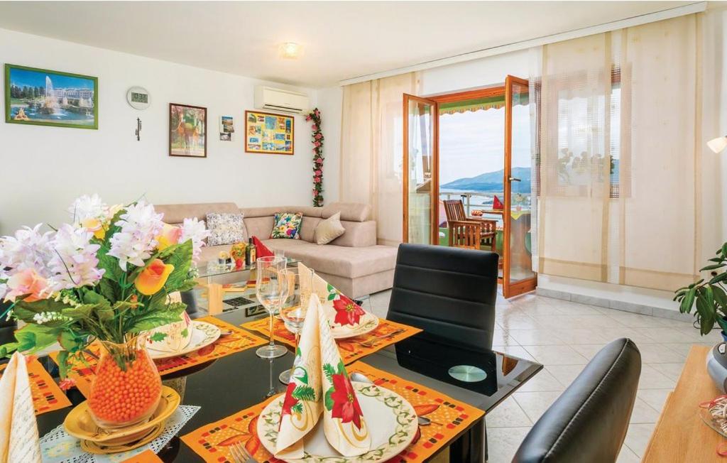 salon ze stołem jadalnym i kwiatami w obiekcie Apartment Zeljko 832 w Rabacu