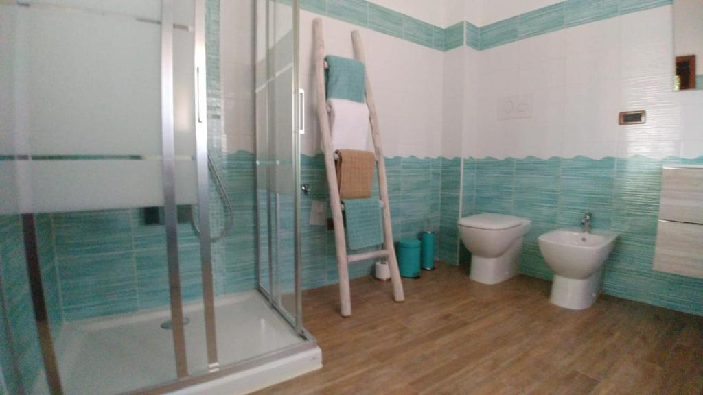 e bagno con servizi igienici e doccia in vetro. di Capo Milazzo Summer Holiday Apartament a Milazzo