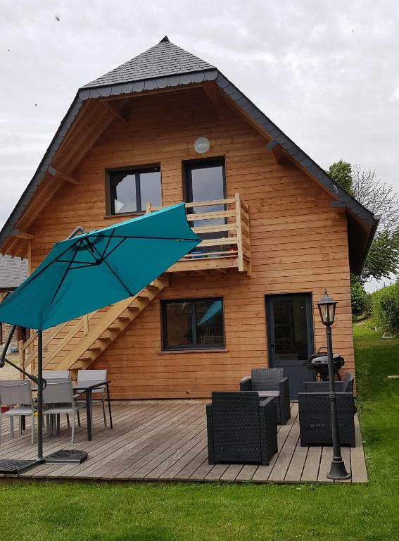 a house with a deck with a blue umbrella at nid cauchois in Betteville