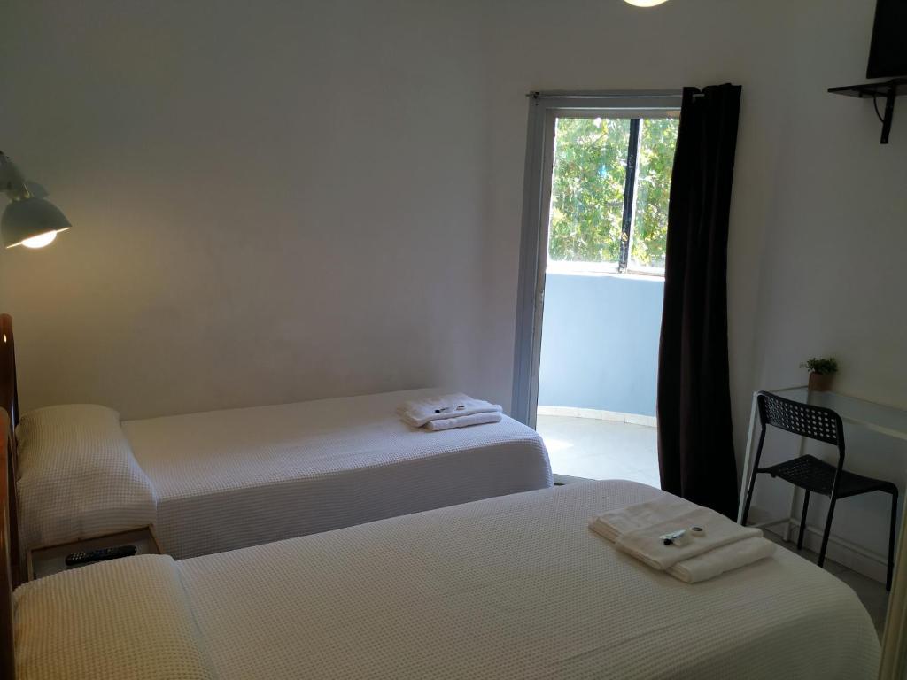 2 camas en una habitación con ventana en Hostal Abitum Madrid, en Madrid