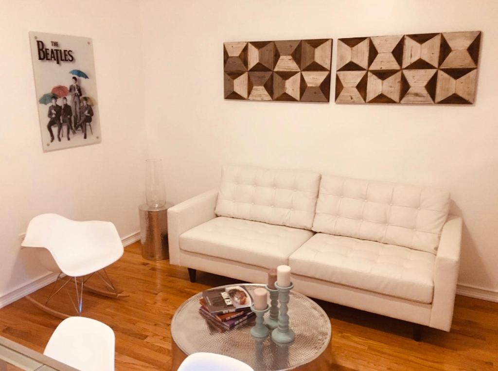 sala de estar con sofá blanco y mesa en Two Bedroom Harlem Apartment en Nueva York