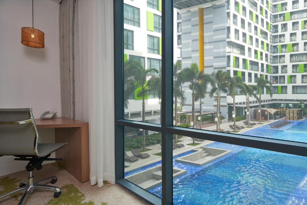 an office with a view of a pool seen through a window at Holiday Inn & Suites Saigon Airport by IHG in Ho Chi Minh City