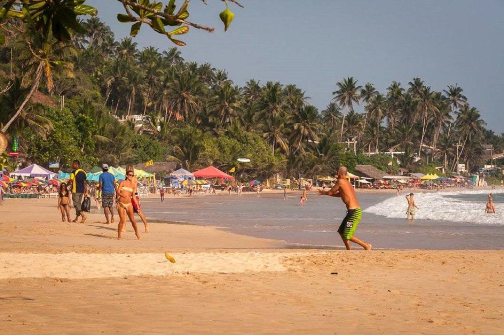 a group of people playing with a frisbee on the beach at Lilac Garden Mirissa in Weligama