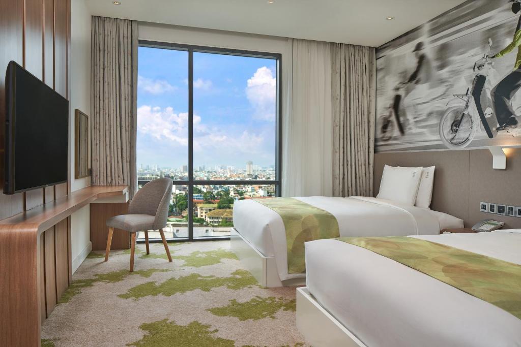 a hotel room with two beds and a television at Holiday Inn & Suites Saigon Airport by IHG in Ho Chi Minh City