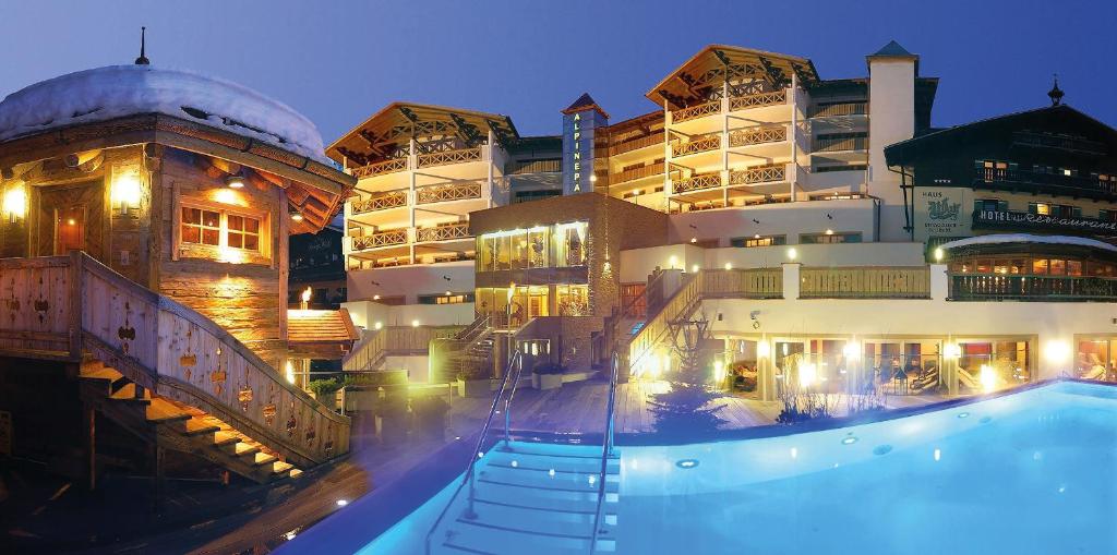 een hotel met een zwembad voor een gebouw bij Hotel Alpine Palace in Saalbach Hinterglemm
