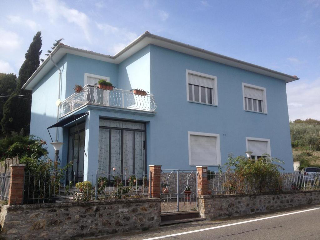 a blue house with a balcony at Belcanto B&B in Montecerboli