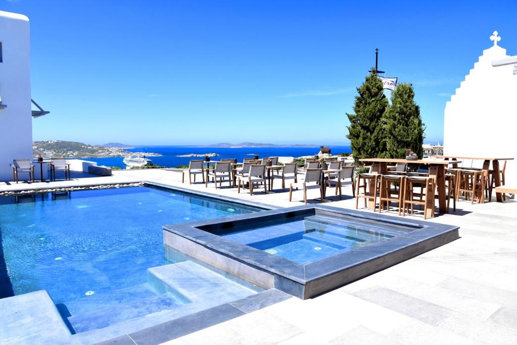 uma piscina com mesa e cadeiras em Aletro Cottage Houses em Míconos