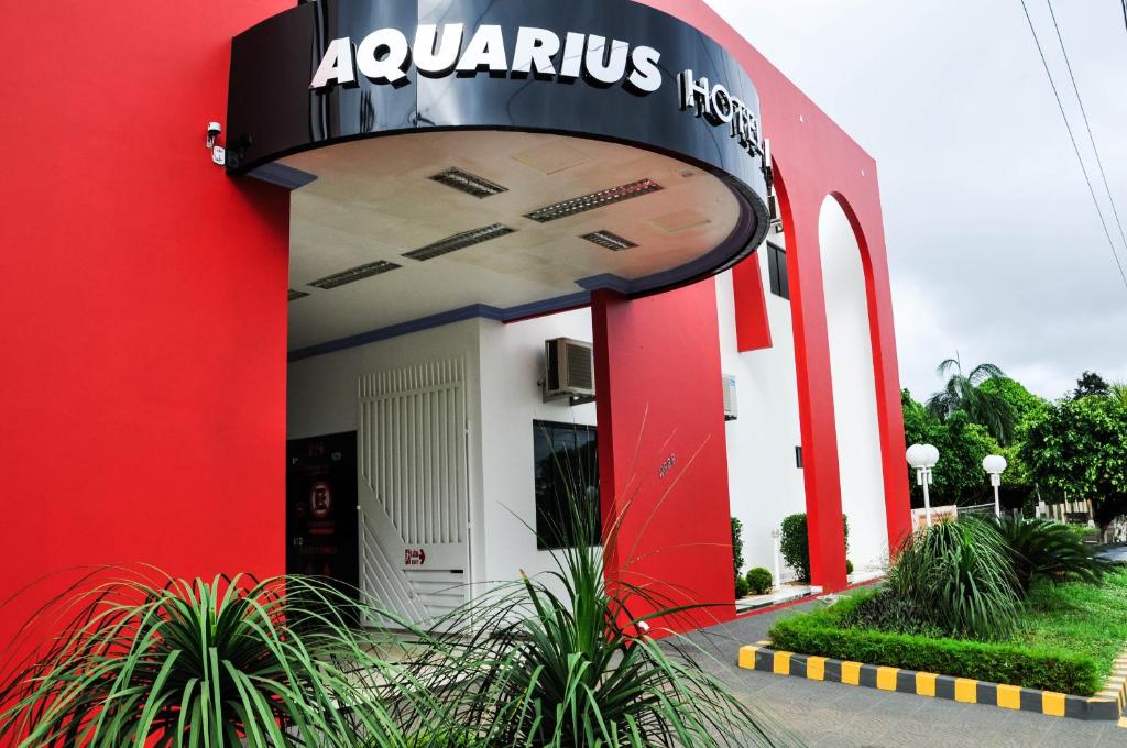 Ariquemes的住宿－Aquarius Hotel Aquarius，一座红色和白色的建筑,上面有标志