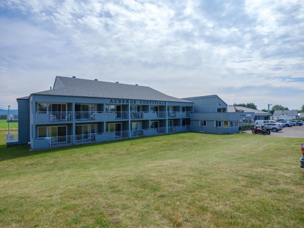 a large building with a large yard in front of it at La Baleine Endiablée Microbrasserie in Rivière-Ouelle