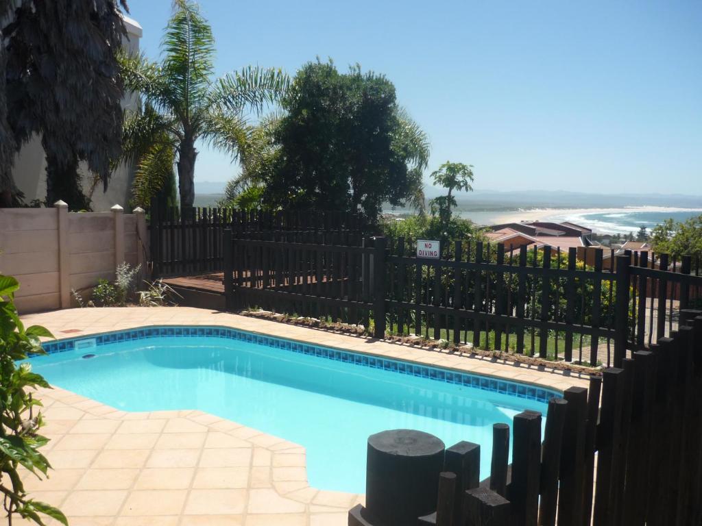 a swimming pool in a yard with a fence at A1Bay View Collection Cottage, Apartment solar power in Jeffreys Bay