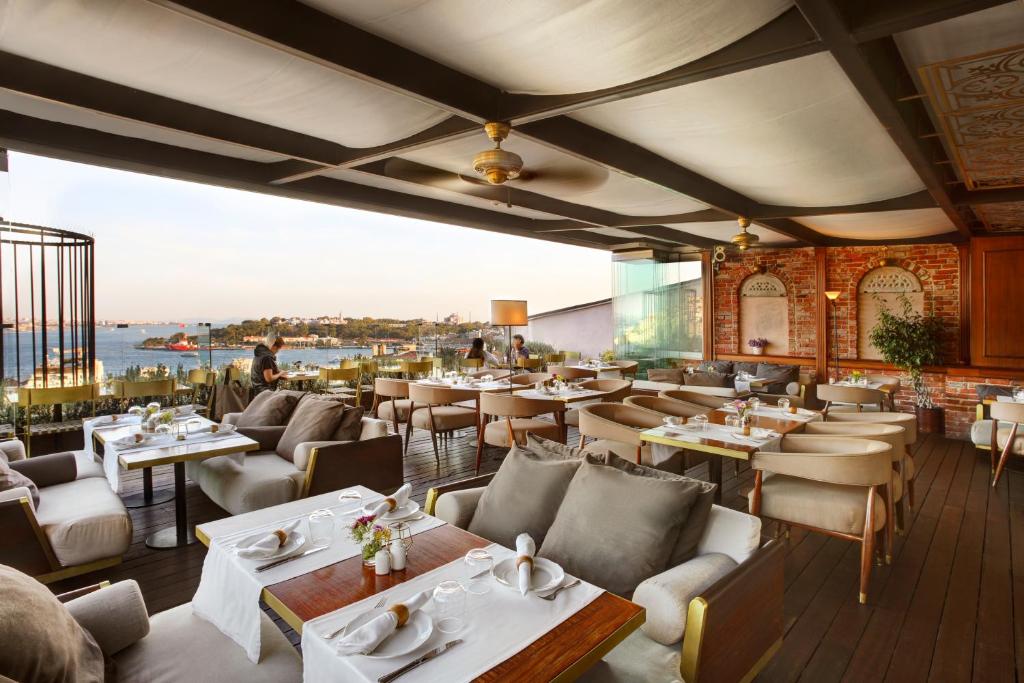 a restaurant with tables and chairs and a view of the water at Georges Hotel Galata in Istanbul
