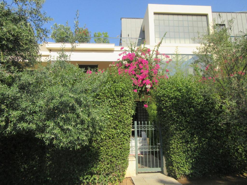 アテネにあるMaison de Familleのピンクの花と茂みの門