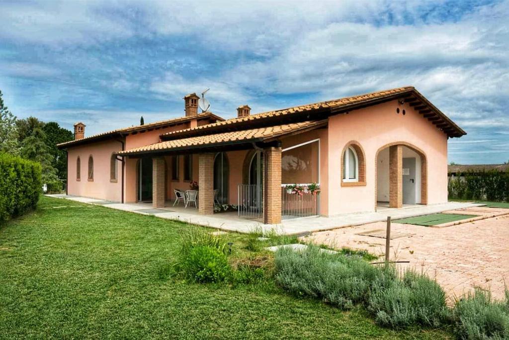 a small house with a grass yard in front of it at L' Aia di Carinda R.T.A. in Grosseto