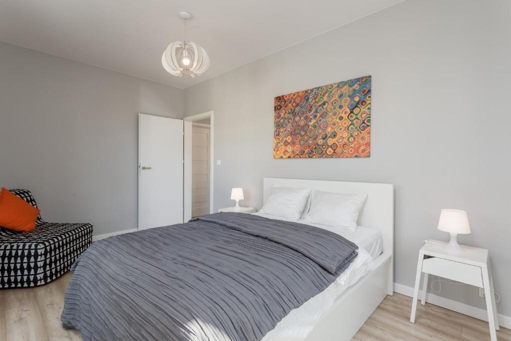 ein Schlafzimmer mit einem Bett und einem Wandgemälde in der Unterkunft Chill Apartments Wolska 45 in Warschau