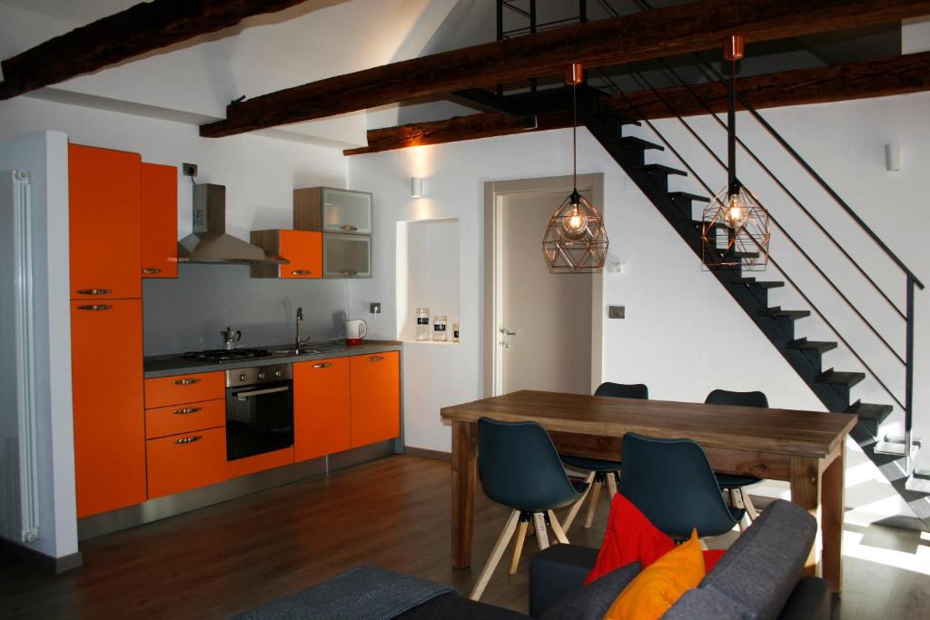a kitchen and dining room with orange cabinets and a table at Ca’ Süler in Crevoladossola