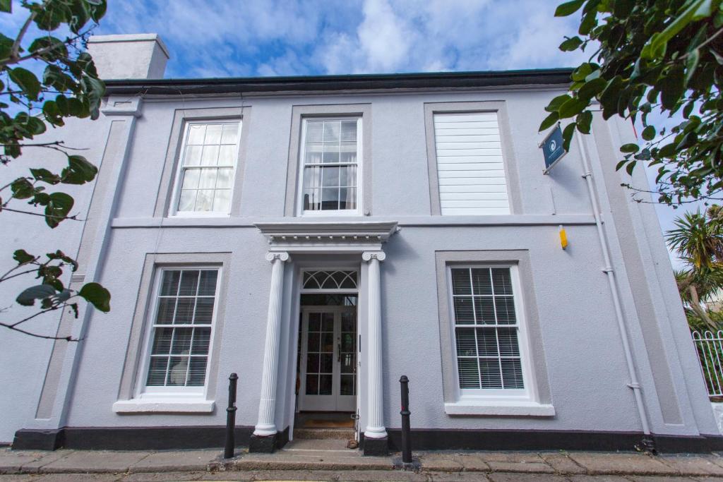 uma casa branca com janelas brancas em The Summer House em Penzance