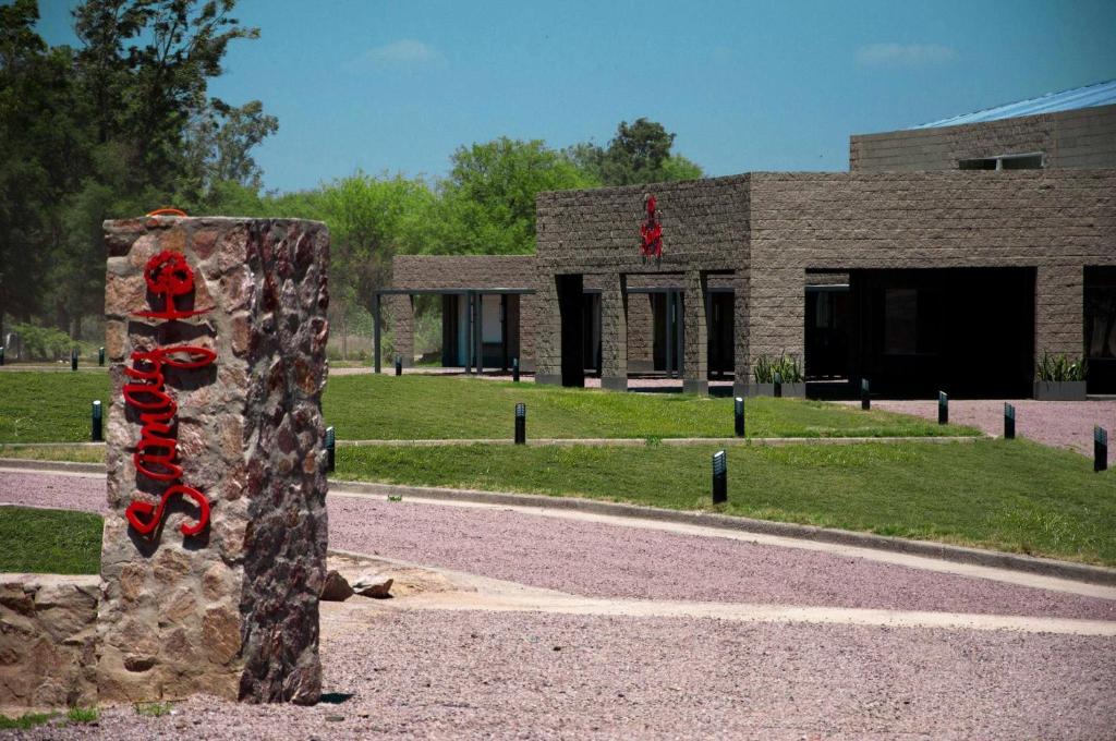 un pilar de piedra con cintas rojas delante de un edificio en Samay Hotel Boutique, en Colonia Dora