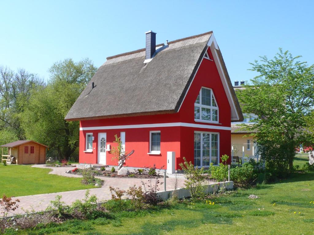 a red house with a gray roof at Ferienhaus Rotmilan in Vieregge