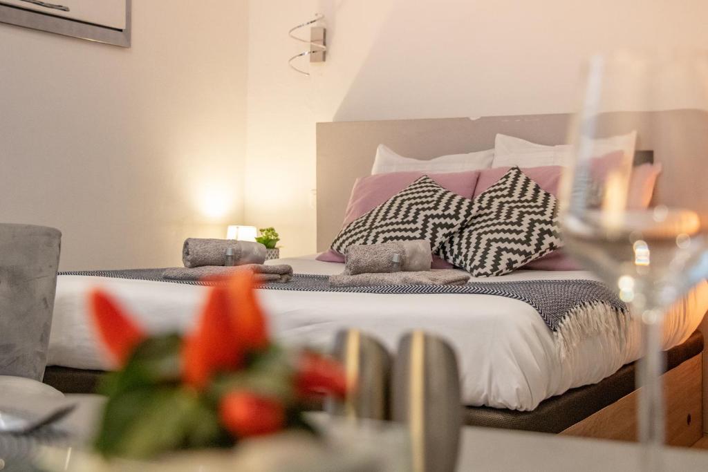 1 dormitorio con 1 cama con almohadas rosas y blancas en Le Paquier - Avec Balnéo - Au Cœur d'Annecy - Majord'Home en Annecy