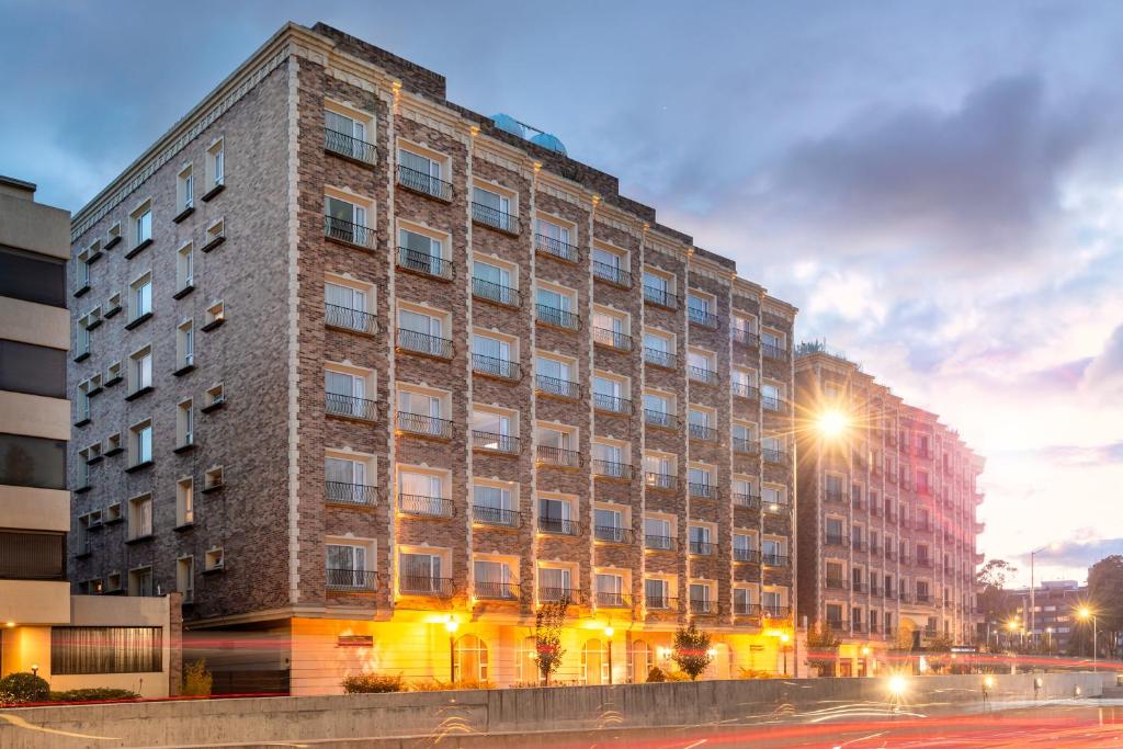 un edificio de ladrillo alto con una luz de la calle delante de él en Apartamentos Dann, en Bogotá