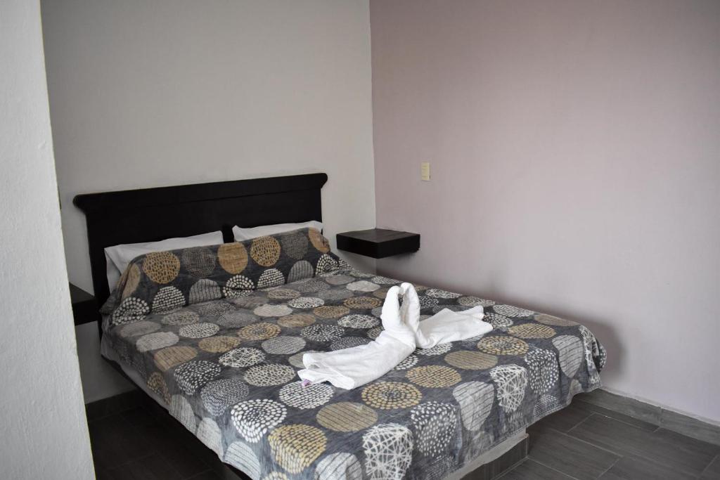 a bedroom with a bed with white shoes on it at HOTEL LOS PINOS CENTRO in Tuxtla Gutiérrez