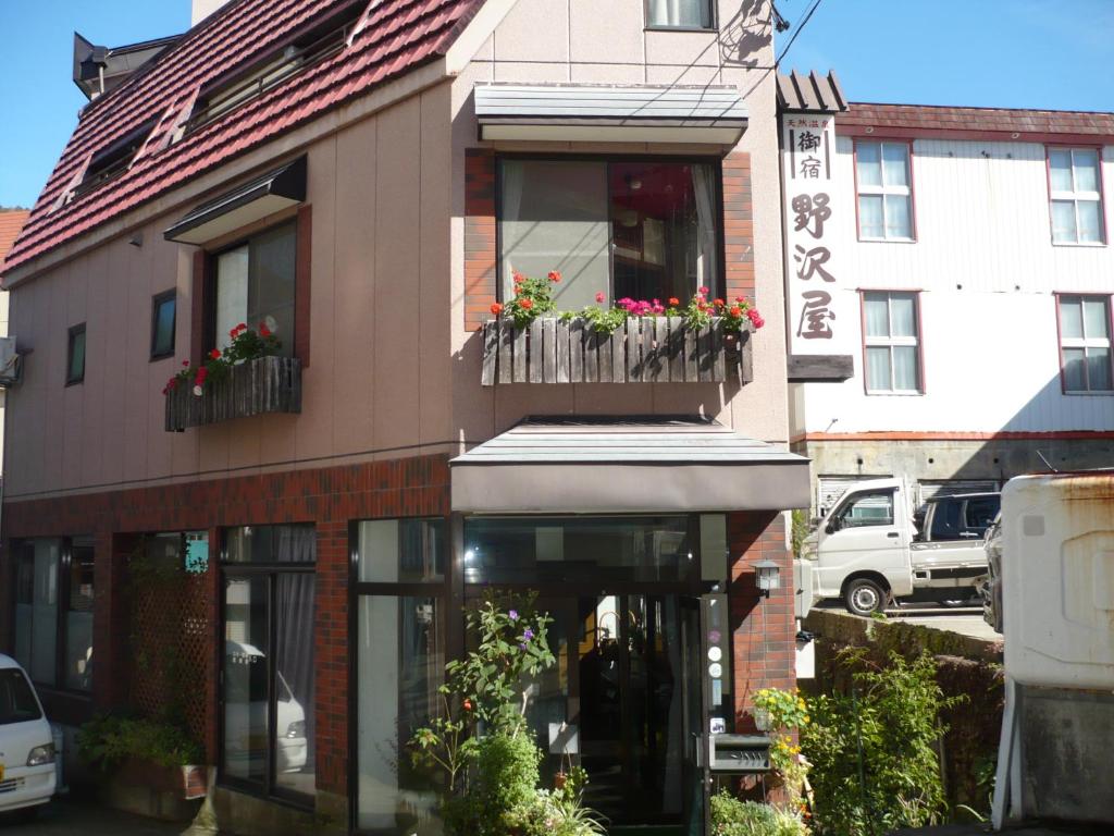 un edificio con un balcón con flores. en Oyado Nozawaya, en Nozawa Onsen