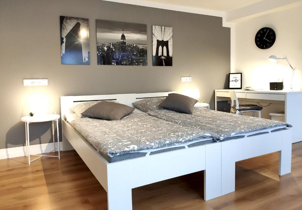 ein weißes Bett in einem Zimmer mit einem Schreibtisch in der Unterkunft Gemütliches Apartment mit WLAN in ruhiger Lage! in Dielmissen