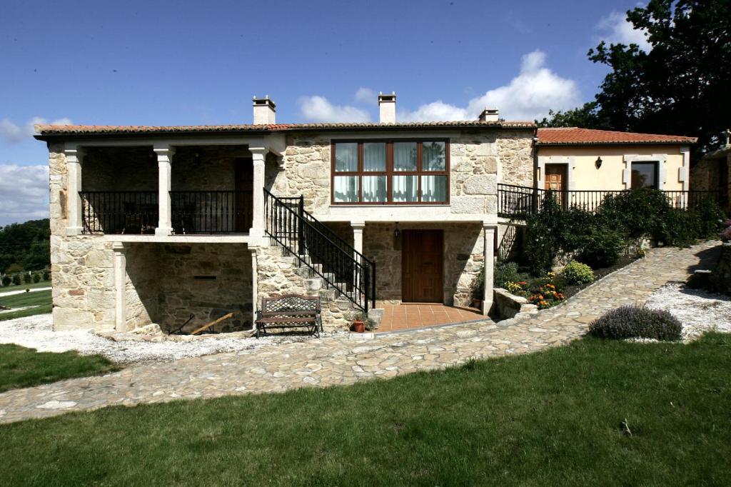 una casa de piedra con una escalera que conduce a ella en Casa da Botica A Estrada, en Os Casares