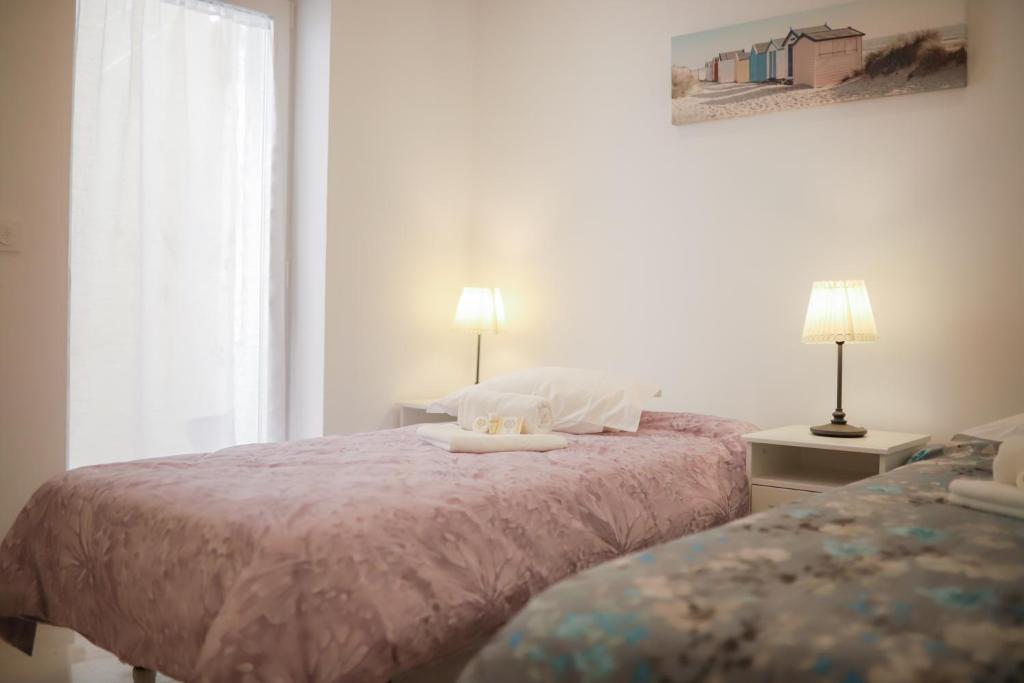 a bedroom with two beds and a window at Apartamento Casino Praia IV in Figueira da Foz