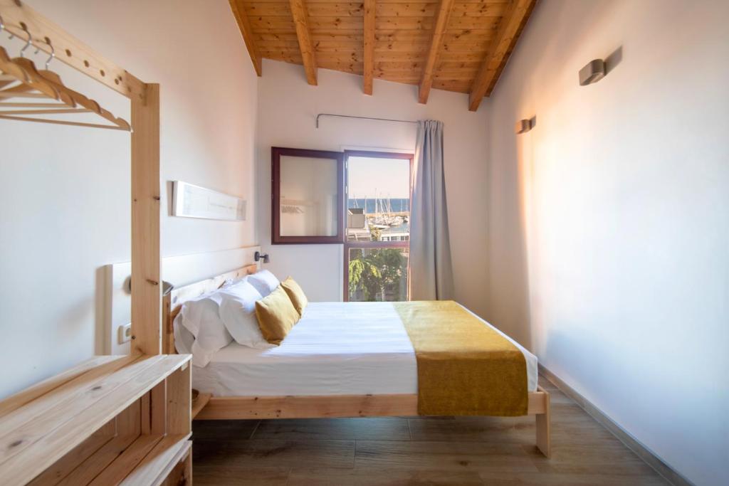 um quarto com uma cama e uma grande janela em ecoGrusApartments em El Masnou