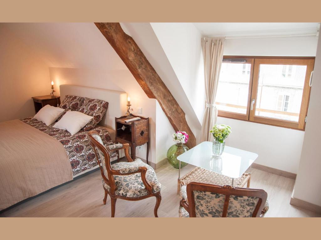 1 dormitorio con 1 cama, mesa y sillas en Villa Mons, en Pontorson