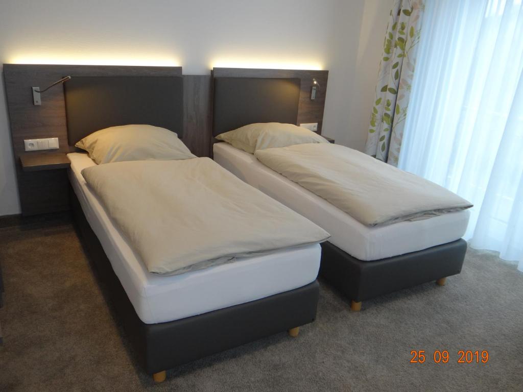dwa łóżka siedzące obok siebie w pokoju w obiekcie Apartmenthaus Vogel w mieście Neuhof